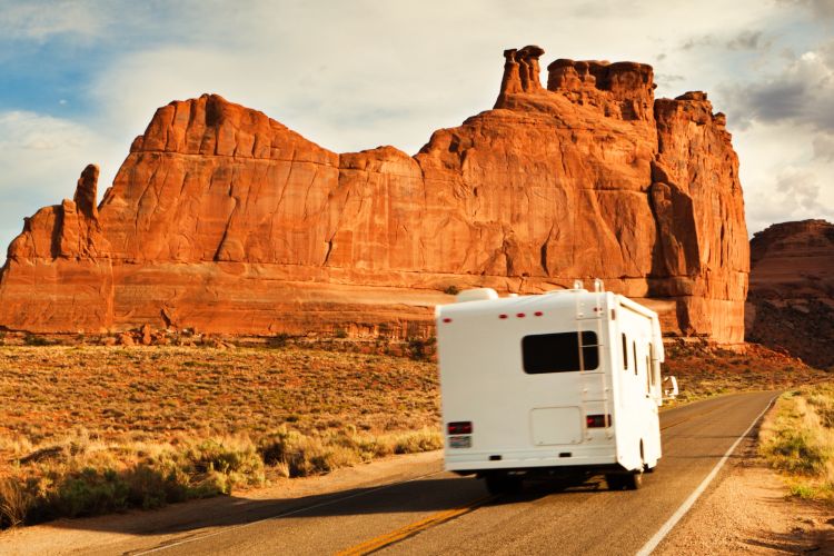 An RV on a road in the US western desert